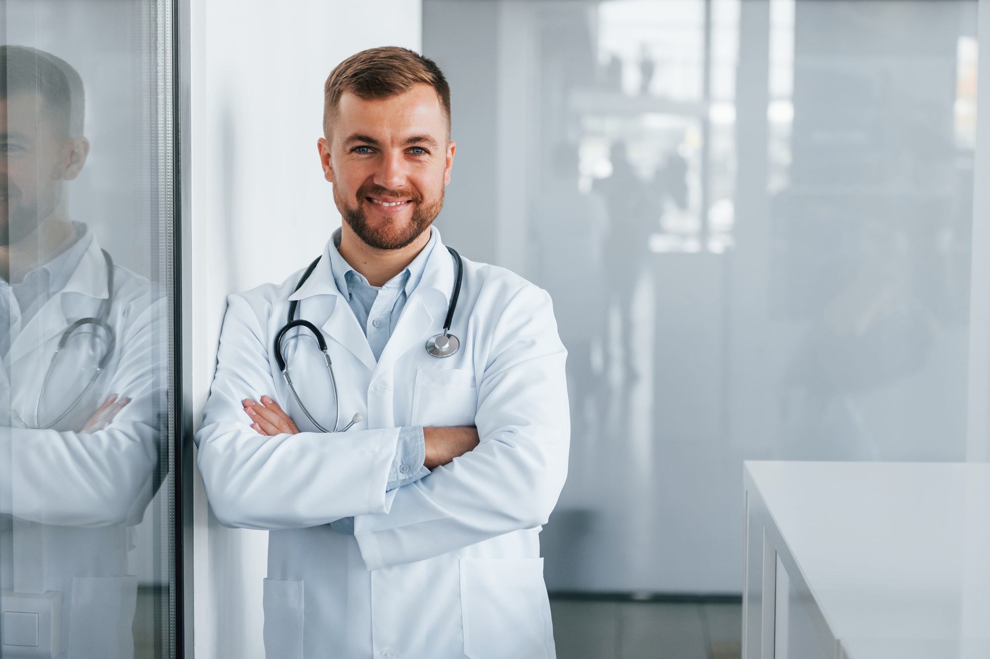 Front view. Professional medic in white coat is in the clinic