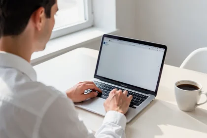 Professionnel rédigeant un texte sur un ordinateur portable à son bureau